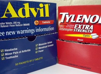 Two boxes of advil and tylenol are sitting on a table.