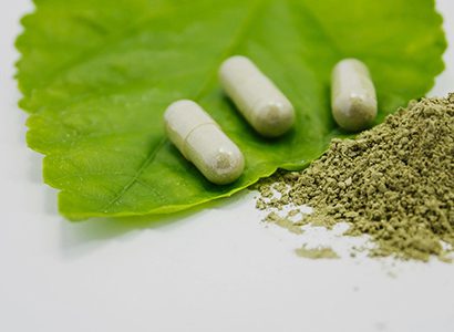 A green leaf with three pills on it.